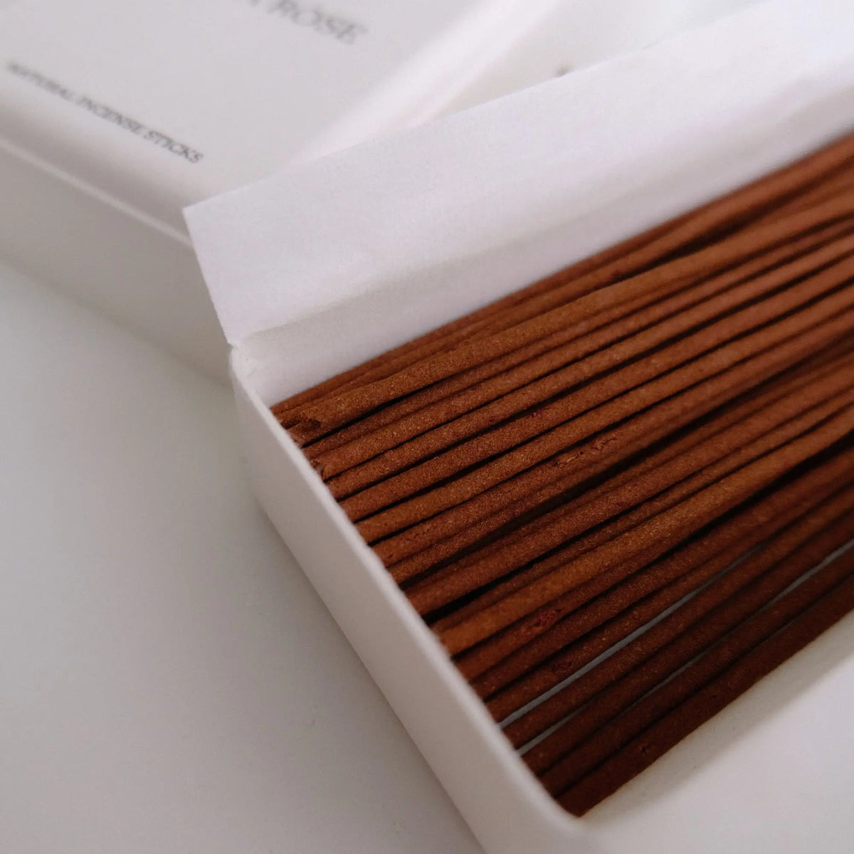 Close view of Laka Rose coreless incense sticks beneath the printed paper-box lid.