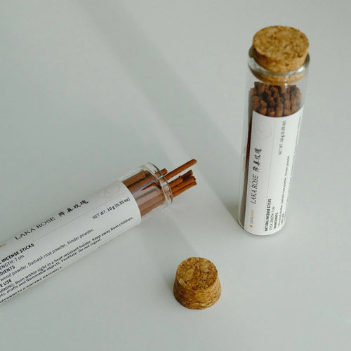 Laka Rose glass sampler tubes, one open, with incense sticks and cork stoppers.