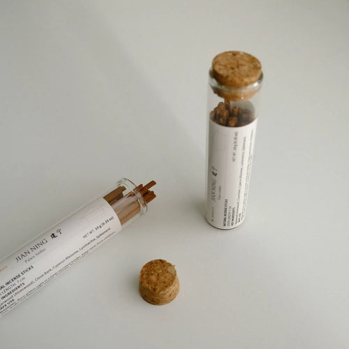 Jianning Palace Amber glass sampler tubes, one open, with incense sticks and cork stoppers.