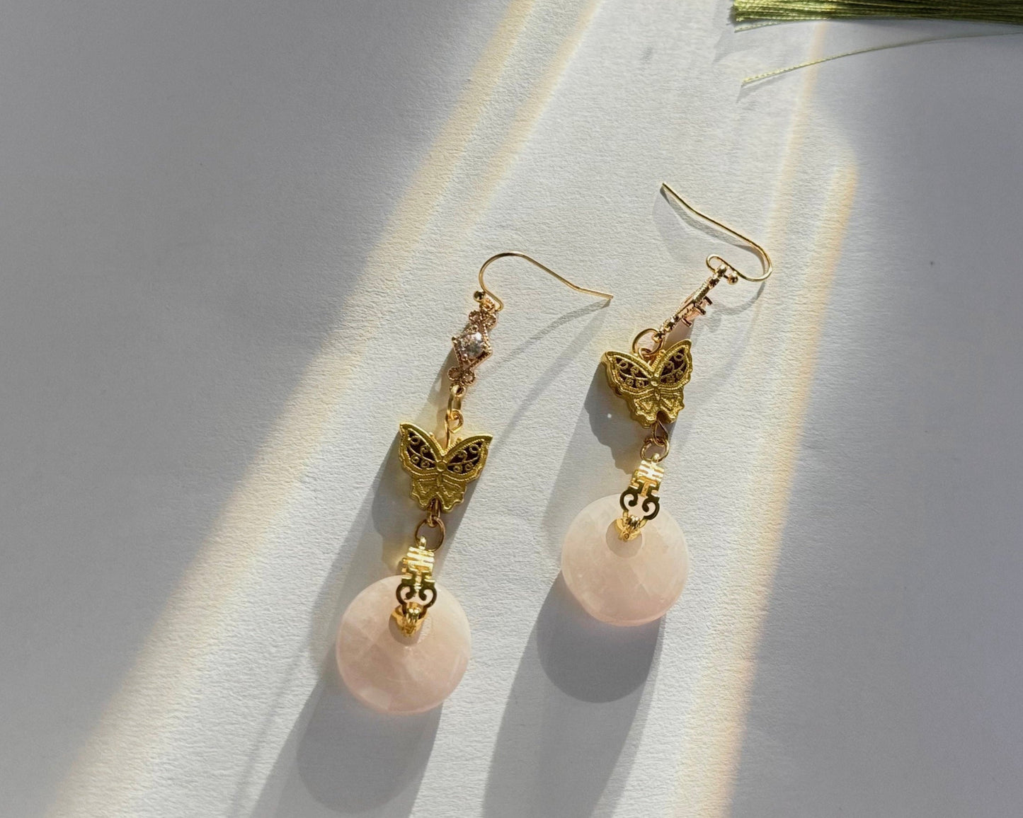 Handmade accessories, Asian / Chinese style earrings, Ethereal Butterfly Jade Drop Earrings, top view, dark background.