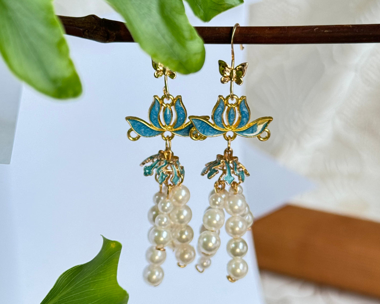 Pearl Drop Earrings. Vintage Asian Kingfisher Collection. Blue lotus flower motif at the top with delicate butterfly accents. Cascading arrangement of white freshwater pearls. Made of vintage Chinese/Asian-inspired kingfisher feather imitation technique.