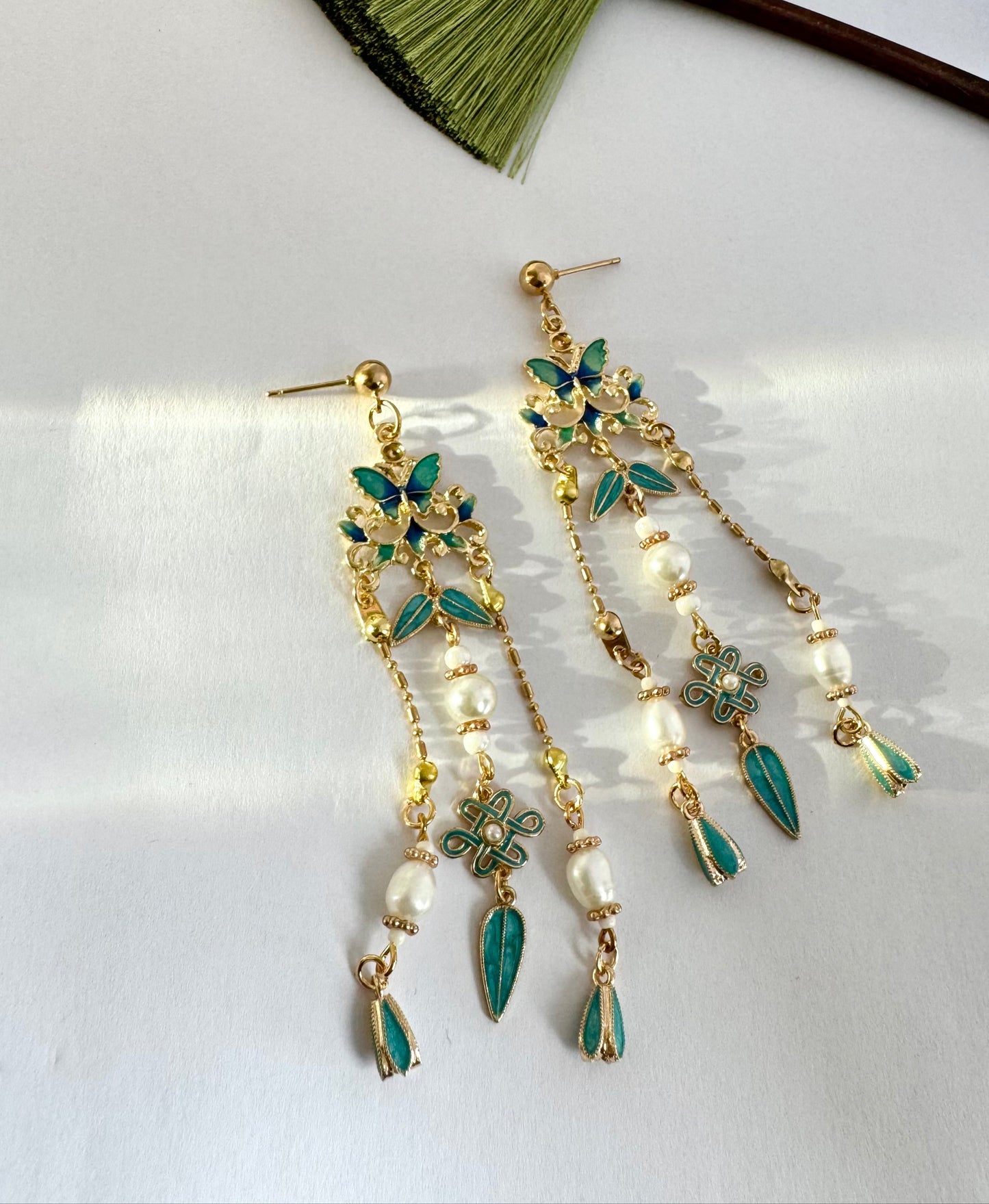 Vintage-inspired butterfly chandelier earrings featuring turquoise enamel butterflies and leaves with gold-tone detailing. Traditional Chinese handmade earrings craft collections