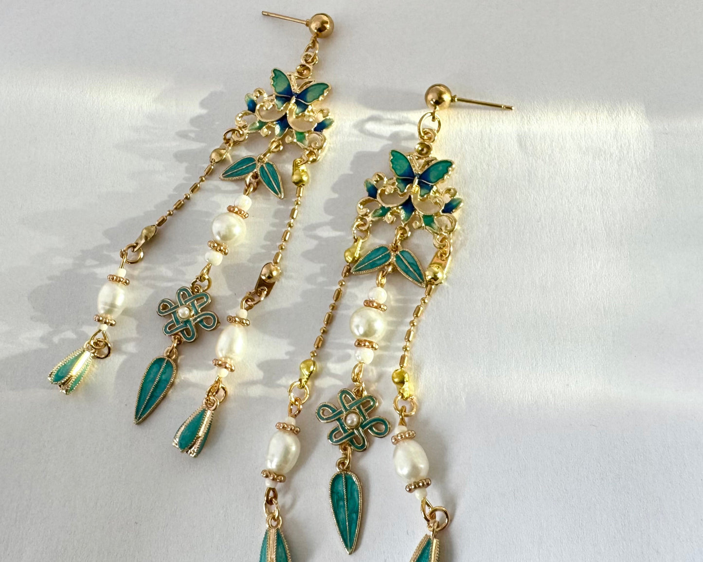 Chinese style earrings, vintage-inspired butterfly chandelier earrings featuring turquoise enamel butterflies and leaves with gold-tone detailing. Unique traditional Chinese handmade earrings craft collections