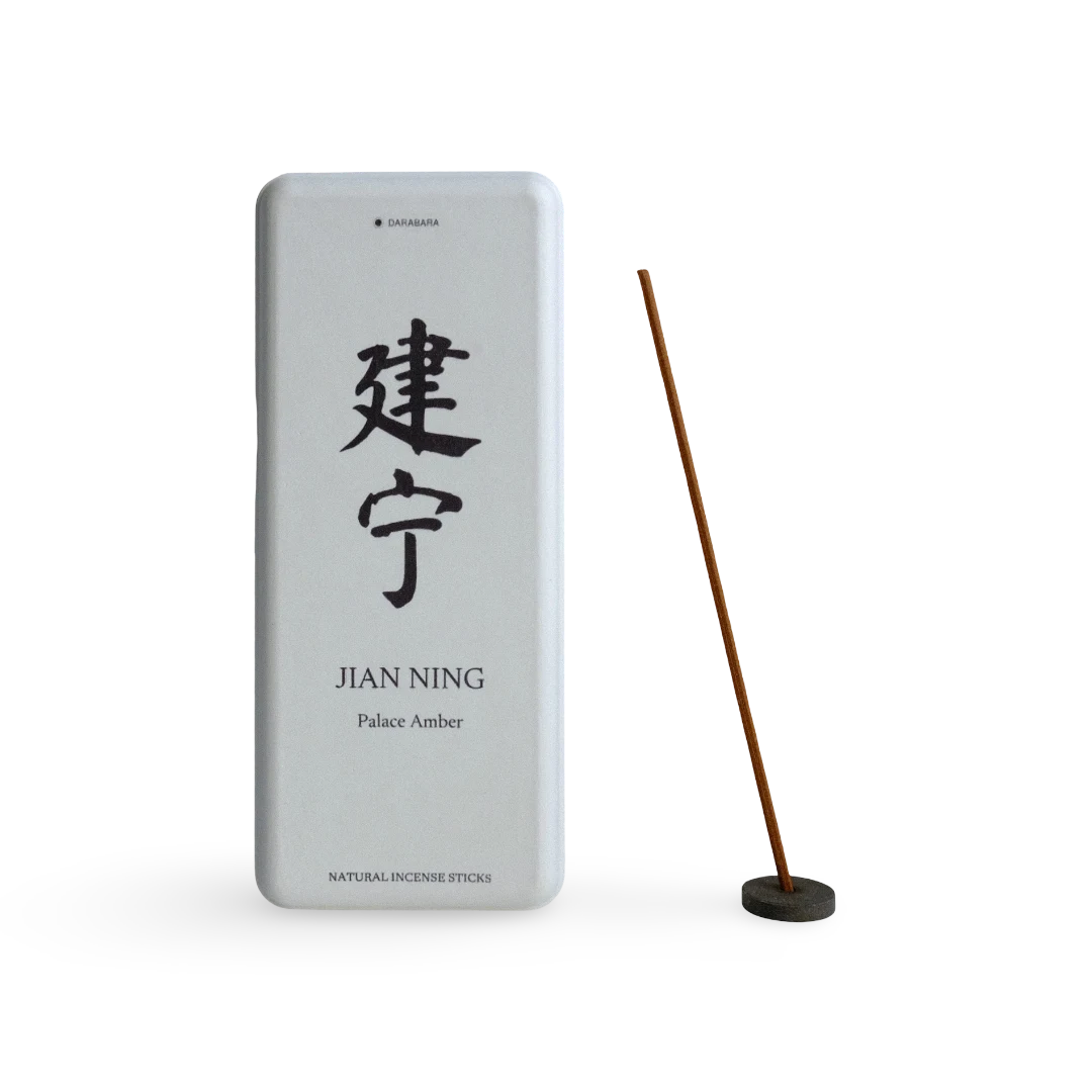 Jianning Palace Amber paper box beside a coreless incense stick in a small round holder.