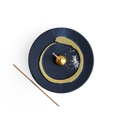 Decorative incense holder with buddhism enso gold circle design on a white background