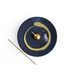 Decorative incense holder with buddhism enso gold circle design on a white background