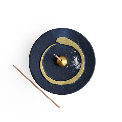 Decorative incense holder with buddhism enso gold circle design on a white background