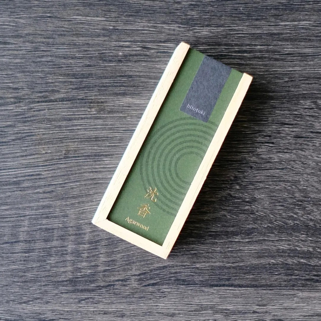Green cover wooden box incense product packaging on a wooden surface with Kousaido Hitotoki logo
