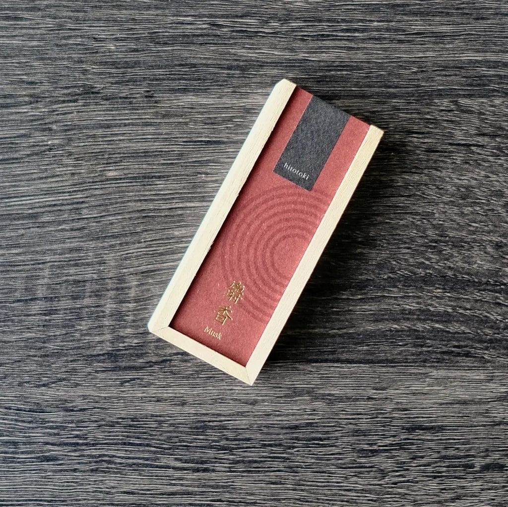 Rectangular wooden incense box product with red Kousaido hitotoki label on a dark wooden surface