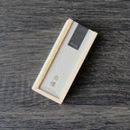 Rectangular Kousaido incense box with a textured surface on a wooden table