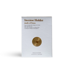 Brass incense holder packaging with text on a white background