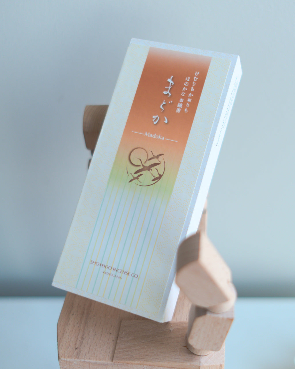Incense packaging with a Shoyeido brand logo on a wooden hand-shaped stand against a light background