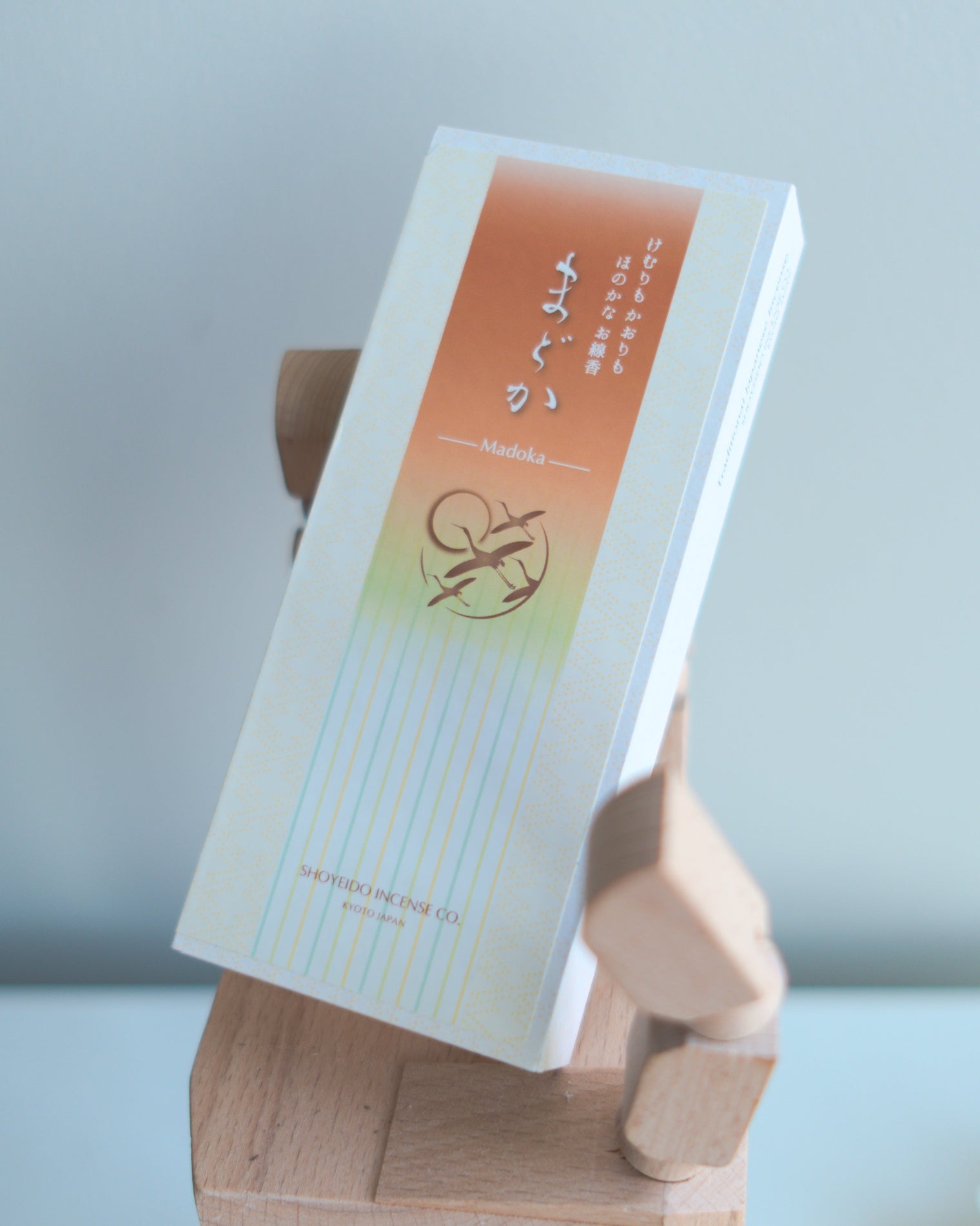 Incense packaging with a Shoyeido brand logo on a wooden hand-shaped stand against a light background