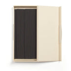 Black incense sticks in a beige box on a white background