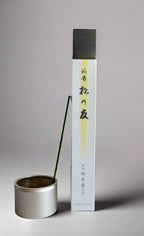A package of Shoyeido 'Matsu no Tomo' incense with a single incense stick burning in a holder.