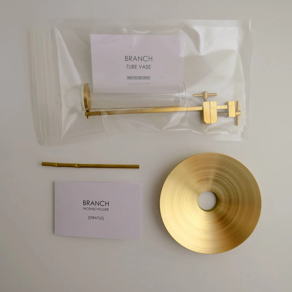 Gold decorative items including a vase, holder, and disc on a white surface with 'Branch' branding.