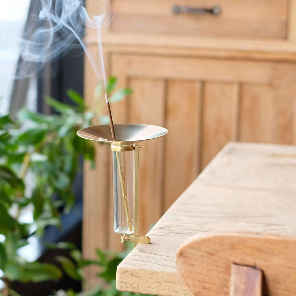 Incense burner with smoke on a wooden surface with a blurred background