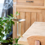 Incense burner with smoke on a wooden surface with a blurred background